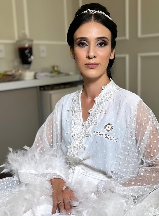 Noiva de robe de plumas com tiara e maquiagem finalizada