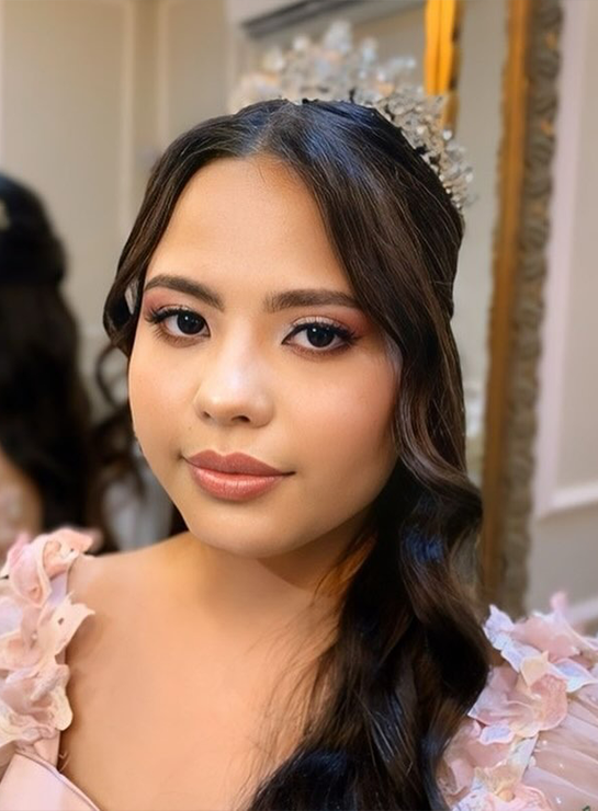 Debutante com tiara, penteado ondulado e maquiagem em tons rosados